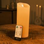 Genopladeligt LED vokslys DORSETTO Ø7,5 × H20 cm – varm hvid på træbord med fjernbetjening