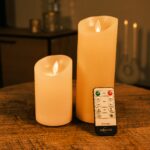To genopladelige LED-vokslys i forskellige højder fra DORSETTO på et træbord med fjernbetjening og blød stemningsbelysning