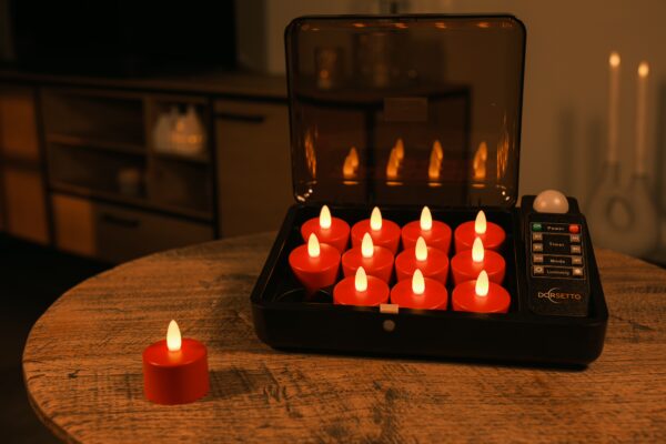 Et sæt røde LED fyrfadslys i et sort opladningsetui står på et træbord med et lys uden for etuiet. Et indikatorpanel for opladning og en fjernbetjening er synlige ved siden af lysene.