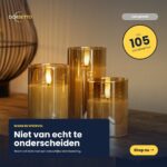 Tre genopladelige DORSETTO LED-lamper (sæt med 3) lyser med et hyggeligt skær. Bag dem står en lampe med metalfod. Den danske tekst fremhæver det realistiske lys og den imponerende brændetid på 105 timer samt fjernbetjeningen.