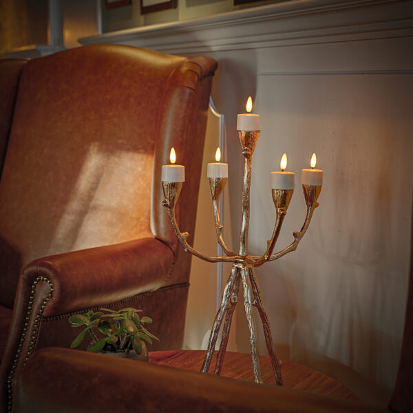 een kandelaar met waxinelichtjes van dorsetto op en tafel bij een rode stoel