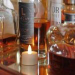 een waxinelichtje van dorsetto bij verschillende flessen wiskey