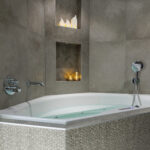 een driehoekig bubbelbad met verschillende waxinelichtjes in de muur