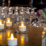 4 waxinelichtjes van dorsetto met veel glazen op de achtergrond