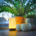 kaarsen houders bij planten die in een mand staan