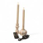 To cremefarvede LED middagslys i hvide holdere med sort fjernbetjening og strømadapter på hvid baggrund, med realistisk flammeeffekt.