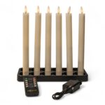 Sæt med seks hvide genopladelige LED-dinerlys på 250 mm i en sort lysestage. Foran lysene ligger en fjernbetjening og en strømadapter med kabel, præsenteret på hvid baggrund.