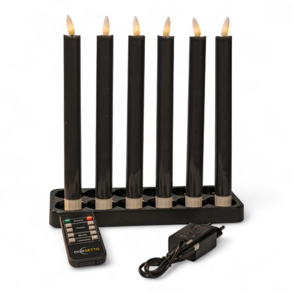 Seks sorte elektroniske stearinlys med flammeformede lys er arrangeret i en rektangulær sort base. Foran er der en fjernbetjening og en strømadapter på en hvid baggrund.