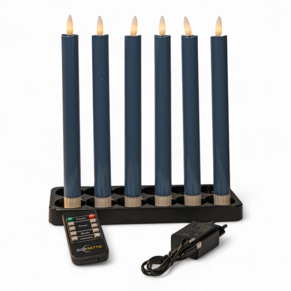 Seks mørkegrå LED-dinerlys på 250 mm i en sort lysestage. Sættet er genopladeligt, dæmpbart og udstyret med timerfunktion. Foran lysene ligger en fjernbetjening og en strømadapter, alt præsenteret på hvid baggrund.